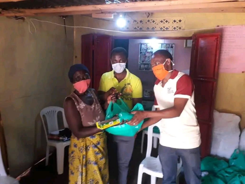 Foundation volunteers handing a food package to a woman in her home