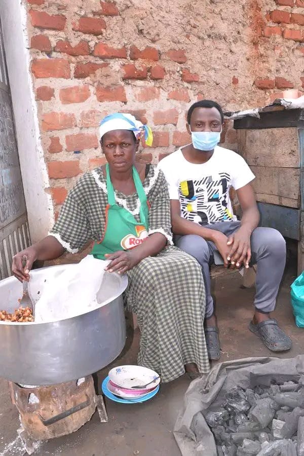 A mother preparing food at her roadside stall to earn an income