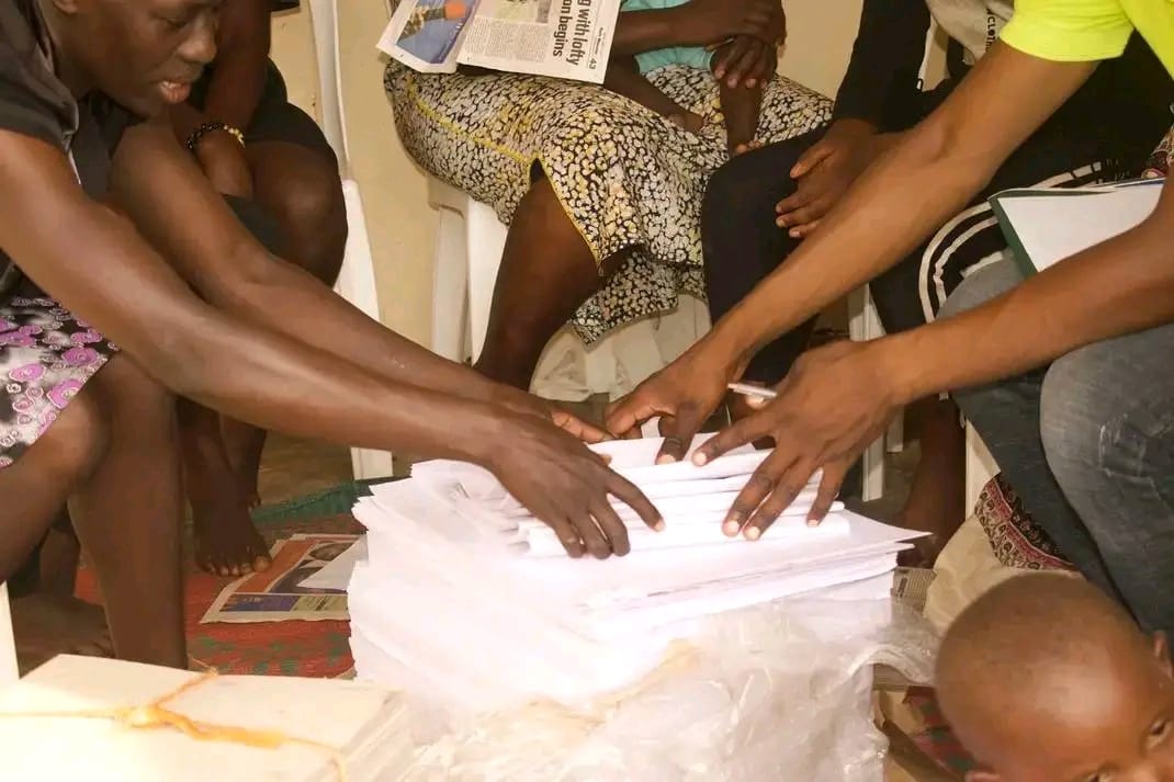 Participants sorting stacks of printed schoolbook pages